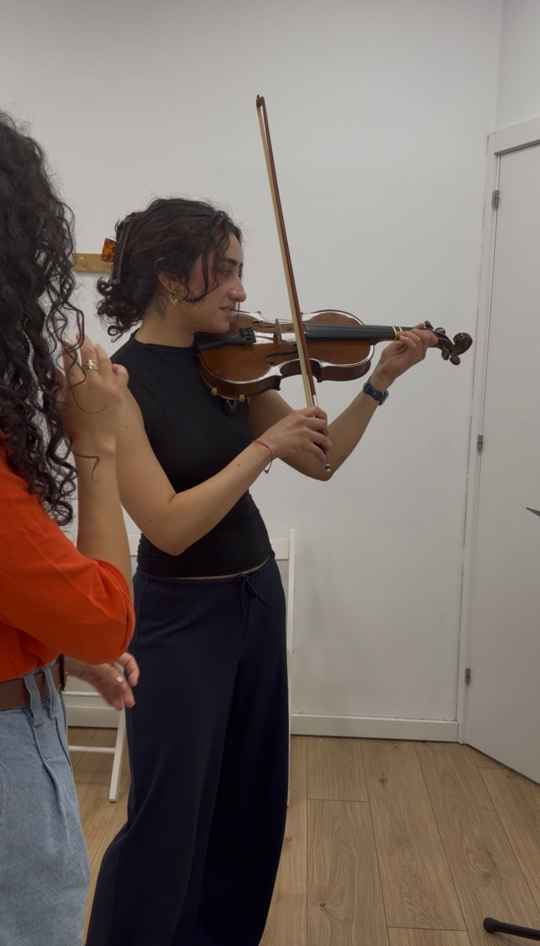 Alumna tocando el violín en una clase presencial